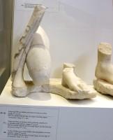 Akr 160+161. Τμήμα πλίνθου με πόδια γονατιστού άντρα με ιμάτιο. Αρχές 5ου αιώνα π.Χ.