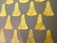 22. Χρυσά επίρραπτα ελάσματα τριγωνικού σχήματος με έκτυπη διακόσμηση σπειροειδών θεμάτων. Επιπλέον εκθέματα.
