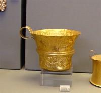 73. Gold cup with repoussé representation of dolphins within a seascape.