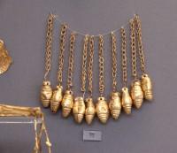 77. Gold pendant in the shape of an acorn (symbol of bounty) hanging from a chain.