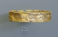 8563. Gold ornament with edges turned inwards to include bronze attachment wire. Grave Alpha.