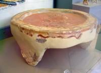 14163. Plaster libation table with painted decoration. A helmeted figure is depicted on one of the legs.