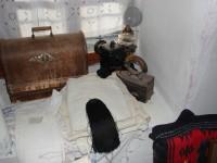 Δεληνάνειο Λαογραφικό Μουσείο: Κεντητές 'κοφτές' κουρτίνες, μία ραπτομηχανή για ρούχα και μία για γούνες/δέρματα, σίδερο-βαποράκι και λάμπα